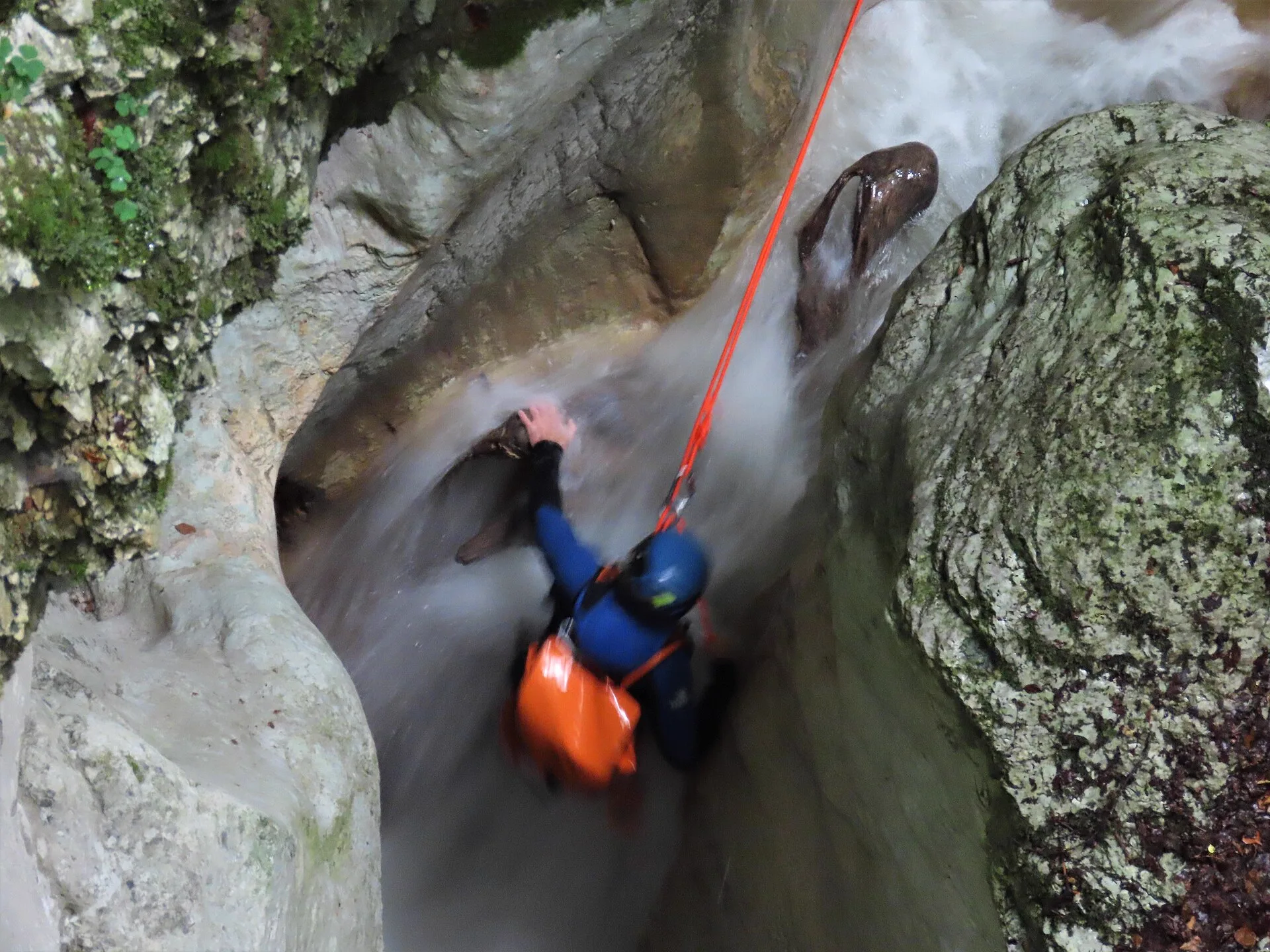 Descente en rappel le long d'un toboggan d'eau dans un canyon encaissé