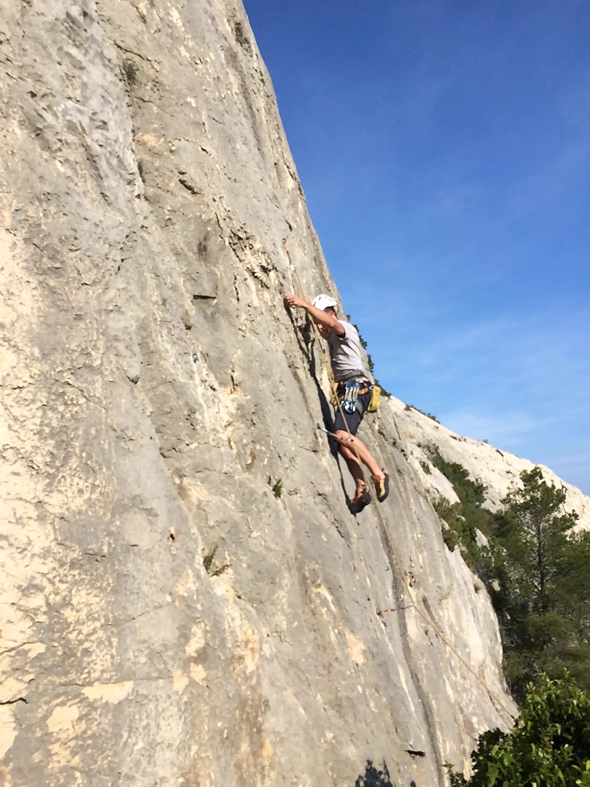 Grimpeur sur une dalle de calcaire blanc dans les Calanques