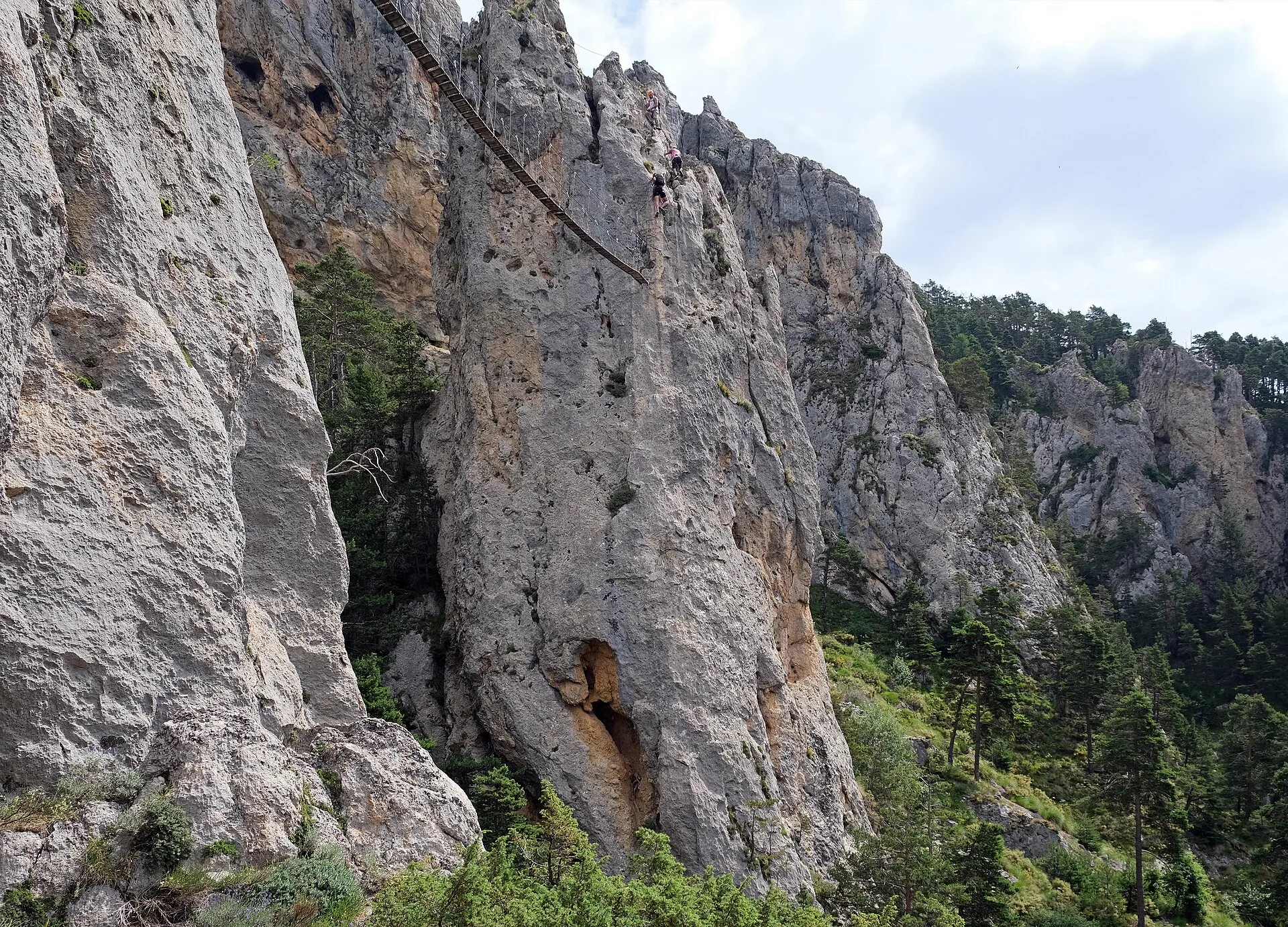 Paroi équipée d'une via ferrata : câble et barreaux fixés dans le rocher